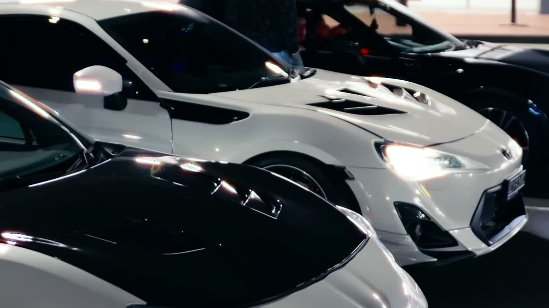 Row of cars parked at a night meet
